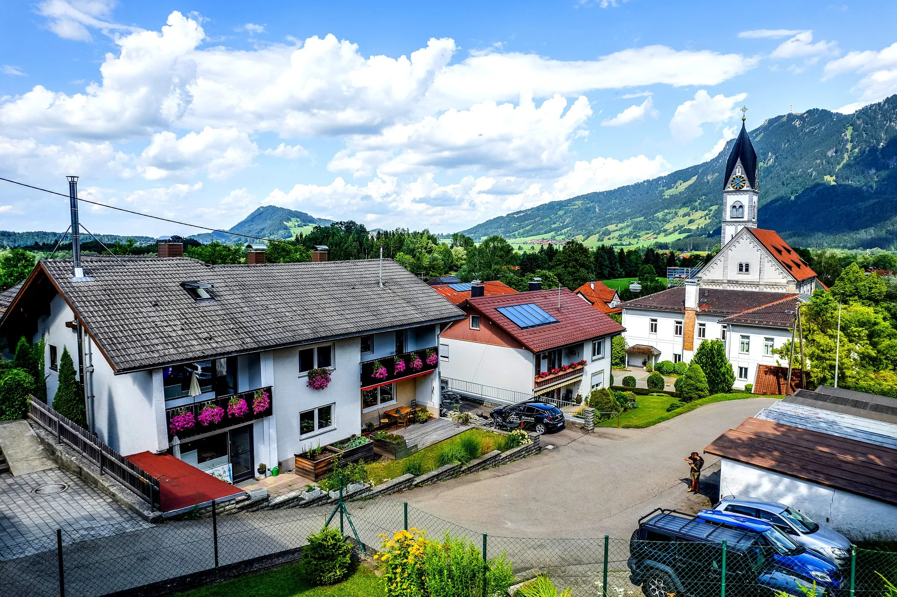 Luftaufnahme von Blaichach im Oberallgäu mit Kirchturm und den Allgäuer Alpen